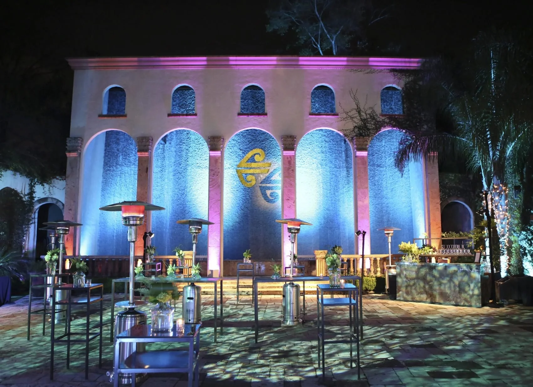 Evening cocktail reception in the courtyard beside the uplit cascading Waterwall arches at The Bell Tower on 34th