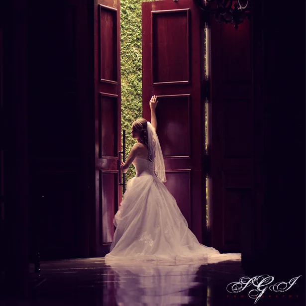 Bride framed by the chapel foyer doors of The Campanile