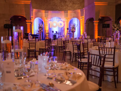 Round dinner tables set with glassware and linens before a corporate gala at The Bell Tower on 34th